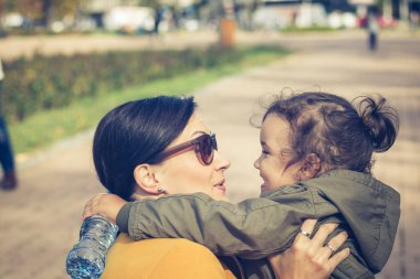 Joyful mother daughter talking face to face. Loving mother and daughter embracing and communicating. 