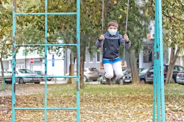 Small Kid Face Mask Swinging Playground Coronavirus Pandemic — Stok fotoğraf