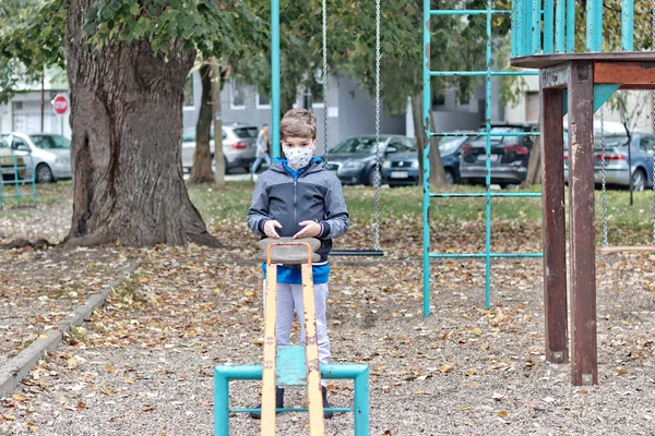Pensive Boy Wearing Face Mask While Playing Alone Playground — Zdjęcie stockowe