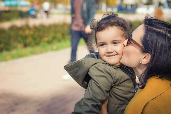 Affectionate mother kissing daughter. Cute little girl being kissed by her mother.