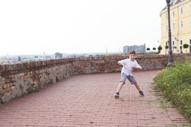 Happy little boy having fun while dancing outdoors. Copy space. 