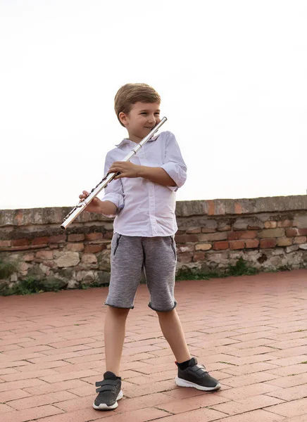 Full Length Child Playing Flute Outdoors — Zdjęcie stockowe