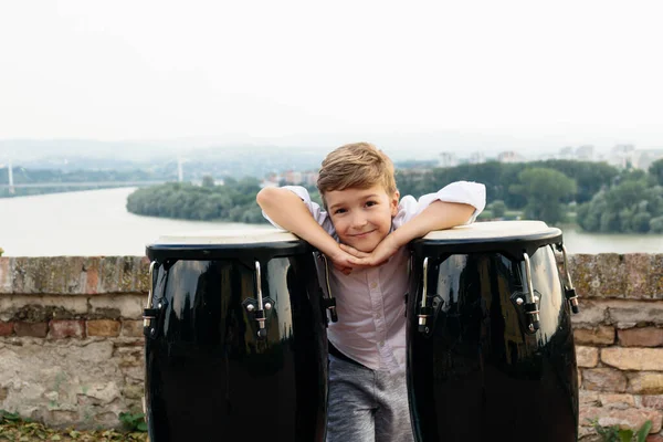 Cute Little Boy Leaning Bongos Looking Camera Riverside — Zdjęcie stockowe