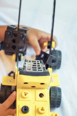 Close up of toy truck. Child playing and assembling construction toy.