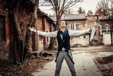 Carefree retro-styled man with arms outstretched standing outdoors and enjoying in freedom. 