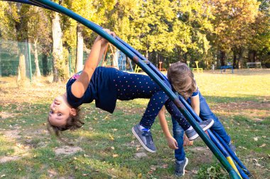 Two carefree kids enjoying while playing in the park. 
