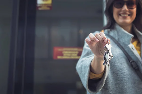 Happy woman with new house keys. Real estate agent showing keys of new apartment.