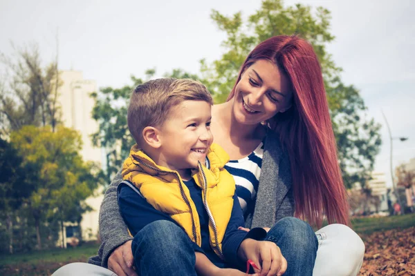 Happy son and mother relaxing in the park and enjoying in time together.