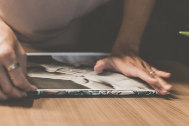 Close up of woman making photo album.
