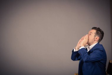 Side view of man shouting against the wall. Copy space. 