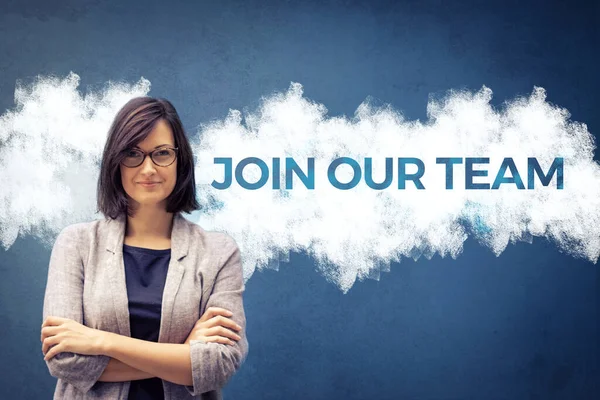 Join our team. Confident businesswoman with arms crossed standing next to sign on the wall. Job search concept.