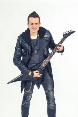 Metal kafalı gitarist elektro gitar çalıyor ve kameraya bakıyor.