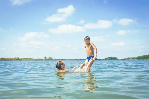 遊び心のある母親と彼女の息子は夏休み中に海で楽しんで — ストック写真