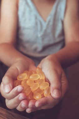 Elleri omega 3 hapıyla dolu bir çocuğa yaklaş..  