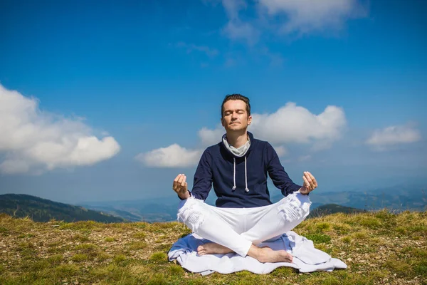 Gözleri kapalı barışçıl bir adam Lotus pozisyonunda meditasyon yapıyor ve doğada yoga yapıyor. Boşluğu kopyala. 
