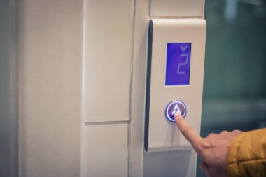 Oteldeki asansörü kullanıp düğmeye basan adama yaklaş..