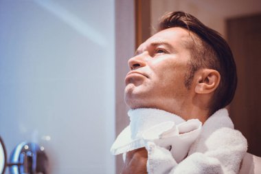 Banyoda yüzü havluyla temizleyen adam.. 