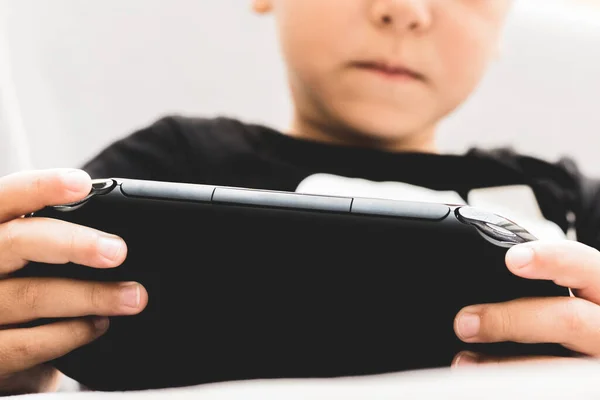 Taşınabilir aygıtla oyun oynayan küçük oyuncuyu kapat.