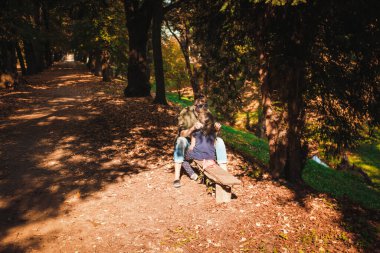 Sevgi dolu anne ve kız parkta bir bankta oturup iletişim kuruyorlar.. 