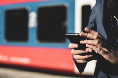 Tren istasyonunda cep telefonu kullanan işadamlarına yaklaş..