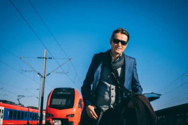 İş saatlerinden sonra tren istasyonunda gülümseyen işadamı.