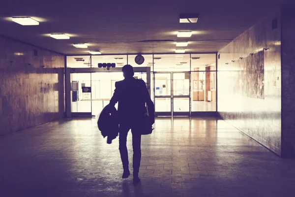 雨の駅の暗い廊下を歩く男のリアビュー — ストック写真