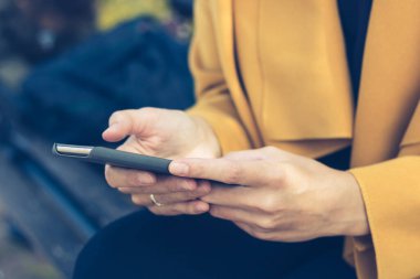 Cep telefonu kullanan bir kadına yaklaş. Akıllı telefonda yazan tanınmayan bir kadın..