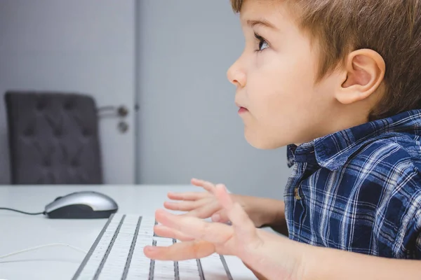Evde bilgisayar oyunu oynayan odaklı çocuk. 