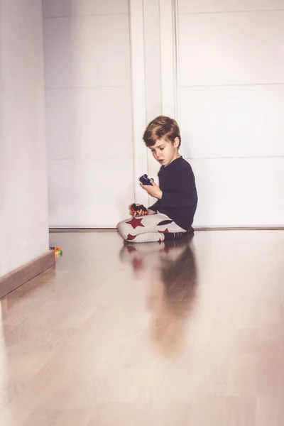 小男孩在家里的地板上玩汽车玩具 — 图库照片