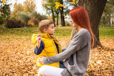 Genç anne ve küçük oğlu güz parkında günlerini geçirirken konuşuyorlar.. 