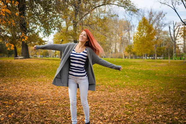 公園で腕を伸ばして自由に楽しむ幸せな赤毛の女性 — ストック写真