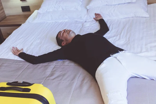 Втомився Чоловік Витягнутими Руками Лежить Ліжку Готельному Номері Під Час — стокове фото