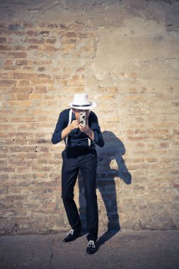 Dışarıdaki modası geçmiş 8 mm 'lik video kamerayla çekim yapan Retro tarzı bir adam..