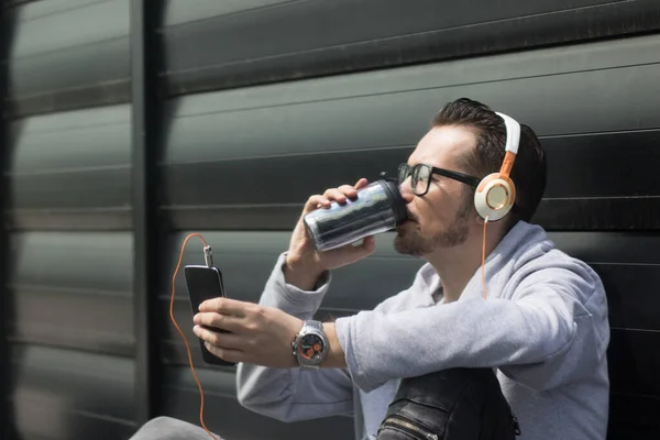 Розслаблений Чоловік Слухає Музику Каву Використовуючи Смартфон Проти Стіни — стокове фото