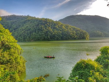 Bir tepe ve bir tekne ile nehir manzarası