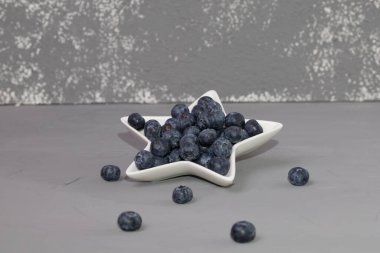 Mahkemede taze yaban mersini, gri arka planda.