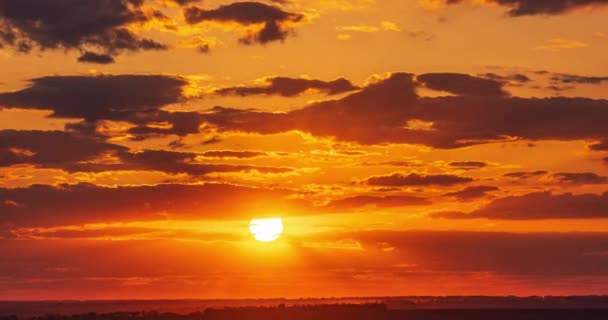 赤い光の中の巨大な明るい太陽が地平線の雲を通過し日没時の経過 — ストック動画