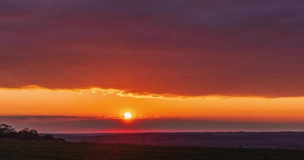 夕阳西下 灿烂的太阳在红色的光芒中穿过地平线上的云彩落下 — 图库视频影像