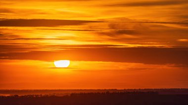 Ukrayna 'nın kırsalındaki yeşil tarlaların üzerinde güzel bir günbatımı