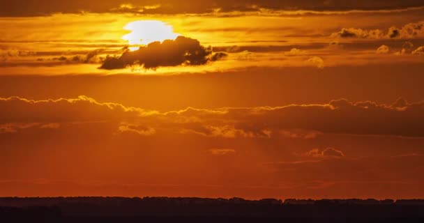 赤い光の中の巨大な明るい太陽が地平線の雲を通過し日没時の経過 — ストック動画