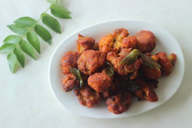 Gobi fry or Gobi 65. A spicy cauliflower starter made with Cauliflower florets marinated in spicy paste of chilli and coriander powder, pepper, ginger garlic paste, corn flour, rice flour and fried
