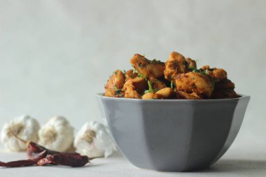 Biberli sarımsaklı tavuk ısırığı. Sert sarımsak aromalı ve taze kişniş yapraklarıyla süslenmiş tavuklu bir tabak. Sarımsak ezmesi, kırmızı biber tozu, sirke, kaymak, yağ, tuz ile marine edilmiş.