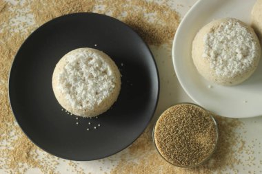 Buğulanmış çiftlik darı unu pastası ya da çiftlik darı puttu. Kerala pirinç buğulama keki, yanında ahır darı unu ve hindistan cevizi karışımı. Beyaz arkaplanda çekilen