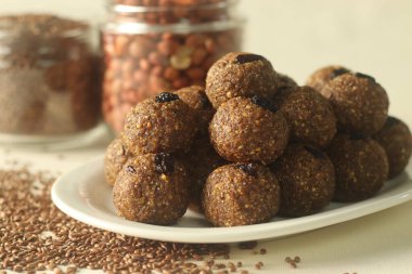 Keten tohumlu fıstık laddu. Hindistan tatlısı, kabaca ezilmiş keten tohumu ve taze rendelenmiş hindistan cevizi ve kakule aromalı yerfıstığı ile yapılır. Yanında kavrulmuş keten tohumu ve fıstık ile vurulmuş.