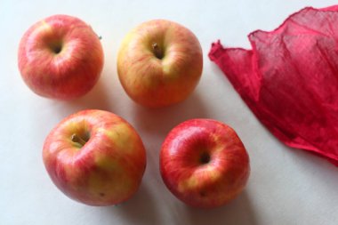 Kırmızı sulu elmalardan oluşan bir mahsul, rastgele yerleştirilmiş ve beyaz arka planda çekilmiş..