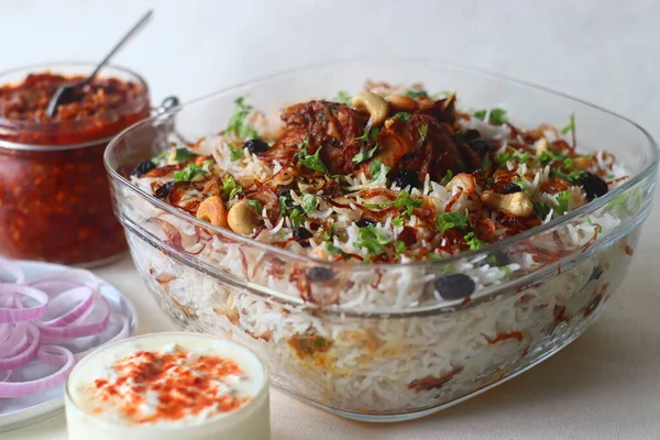 Ghee rice and chicken roast. A rice dish made of basmati rice, ghee, spices and garnished with fried onions, cashews and raisins. Served with kerala style spicy chicken roast. Shot with dates pickle