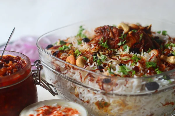 Ghee rice and chicken roast. A rice dish made of basmati rice, ghee, spices and garnished with fried onions, cashews and raisins. Served with kerala style spicy chicken roast. Shot with dates pickle