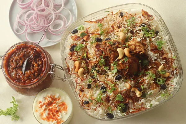 Ghee rice and chicken roast. A rice dish made of basmati rice, ghee, spices and garnished with fried onions, cashews and raisins. Served with kerala style spicy chicken roast. Shot with dates pickle