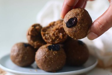 Beyaz laddu. Sağlıklı, lezzetli ve beyaz susam tohumları, jaggery, taze rendelenmiş hindistan cevizi ve kuru üzümle hazırlanmış hindistancevizi tatlısı. Beyaz arkaplanda çekilen