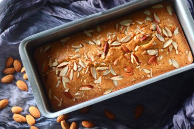 Somun tenekesinin içinde Ghee keki. Vanilya aromalı, bademli kahve pastası. Bir fincan kahve için mükemmel bir eşlikçi. Beyaz arkaplanda çekilen